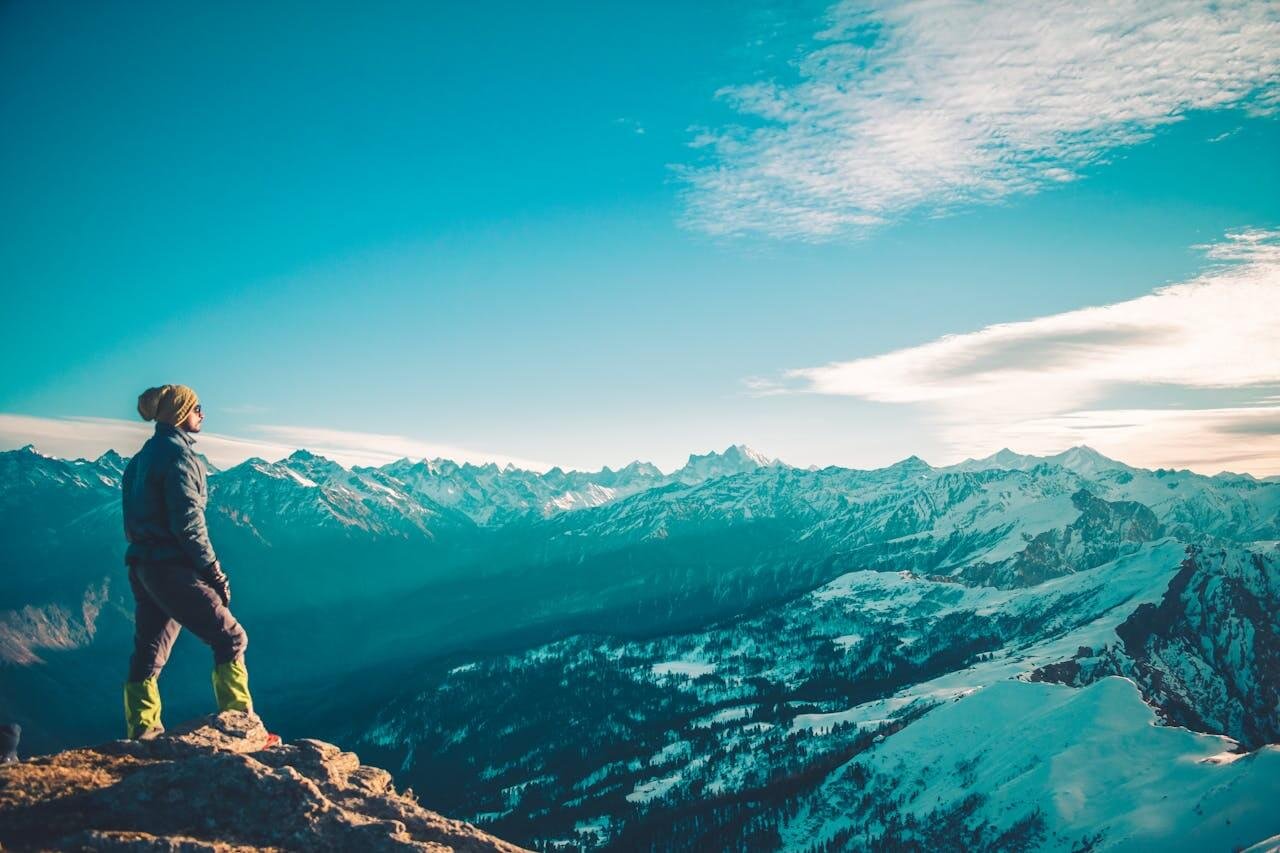 Žmogus stovi ant kalno viršūnės ir žiūri į kalnus – svetainės rezultatai prieš ir po SEO reklamos